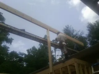 Carpenter setting a ridge beam over a new addition frame — Ice Dam Removal by Roofing Brothers in Edenton