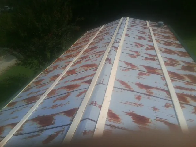 Rusted metal roof panels with new wood purlins before replacement — Storm Damage Roof Repair in Edenton by Roofing Brothers