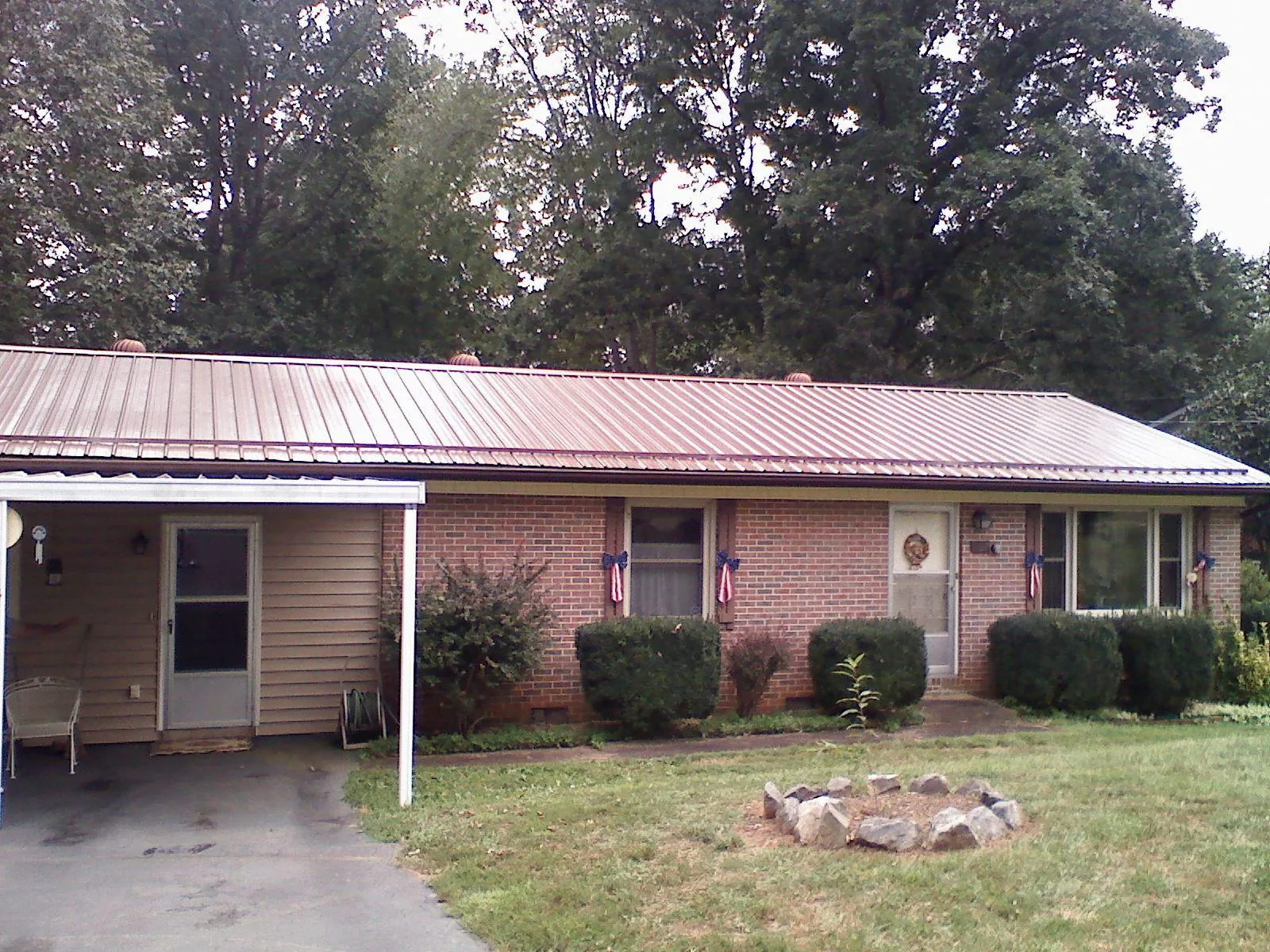 Bronze metal roof and carport on a brick ranch home — Roof Repair work by our crew in Edenton